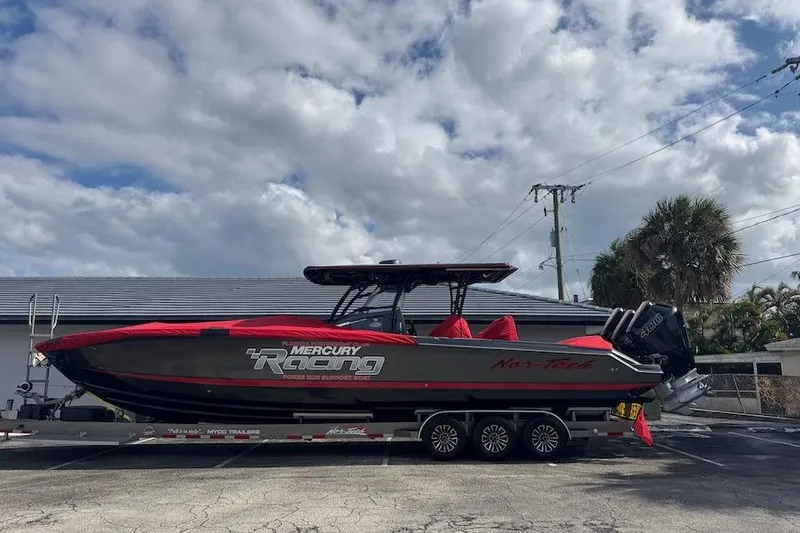 Slide: The Image of 2025 Nor-Tech 390 Sport Center Console boat on trailer, featuring Mercury Racing engines. - 2