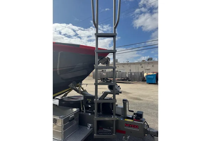 Slide: The Image of 2025 Nor-Tech 390 Sport Center Console on trailer with ladder, under blue sky. - 20