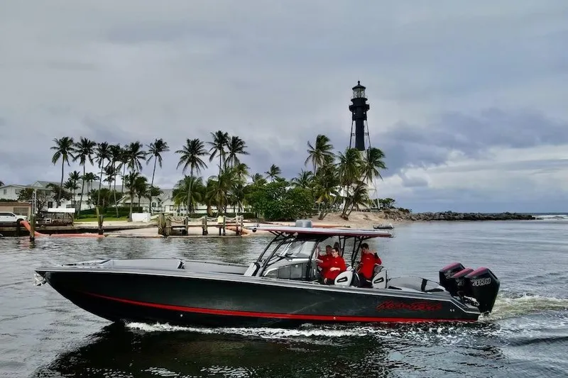 Slide: The Image of 2025 Nor-Tech 390 Sport Center Console boat cruising near a lighthouse and palm trees. - 4