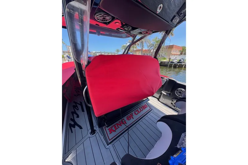 Slide: The Image of 2025 Nor-Tech 390 Sport Center Console interior with red cover and "King of Clubs" mat. - 8
