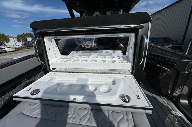 Slide: The Image of 2025 Nor-Tech 390 Sport Center Console with open storage compartment, showcasing sleek design. - 9