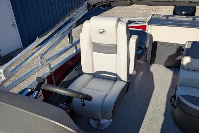 Slide: The Image of 2026 Sun Tracker Fishin' Barge 22 DLX boat interior with captain's chair and steering wheel. - 101