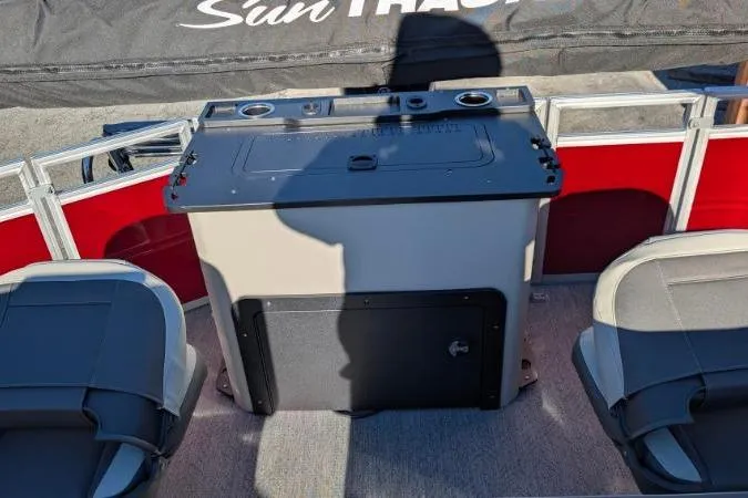Slide: The Image of 2026 Sun Tracker Fishin' Barge 22 DLX interior with seating and storage console. - 4