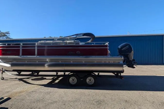 Slide: The Image of 2026 Sun Tracker Fishin' Barge 22 DLX pontoon boat on trailer, parked outdoors. - 97