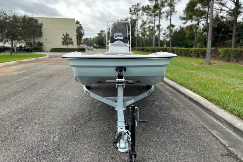 Slide: The Image of 2026 Mako Pro Skiff 15 CC on trailer, parked on a road with greenery. - 4