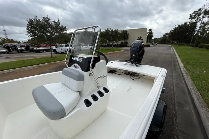 Slide: The Image of 2026 Mako Pro Skiff 15 CC boat with console and seating, parked outdoors. - 6