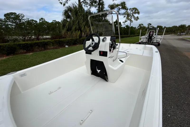 Slide: The Image of 2026 Mako Pro Skiff 15 CC boat with console, parked on a trailer. - 7