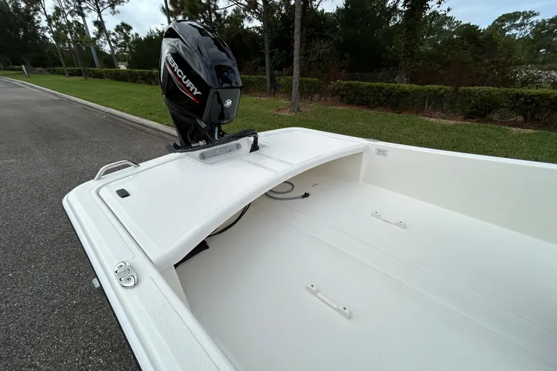 Slide: The Image of 2026 Mako Pro Skiff 15 CC boat with Mercury engine, parked on roadside. - 8