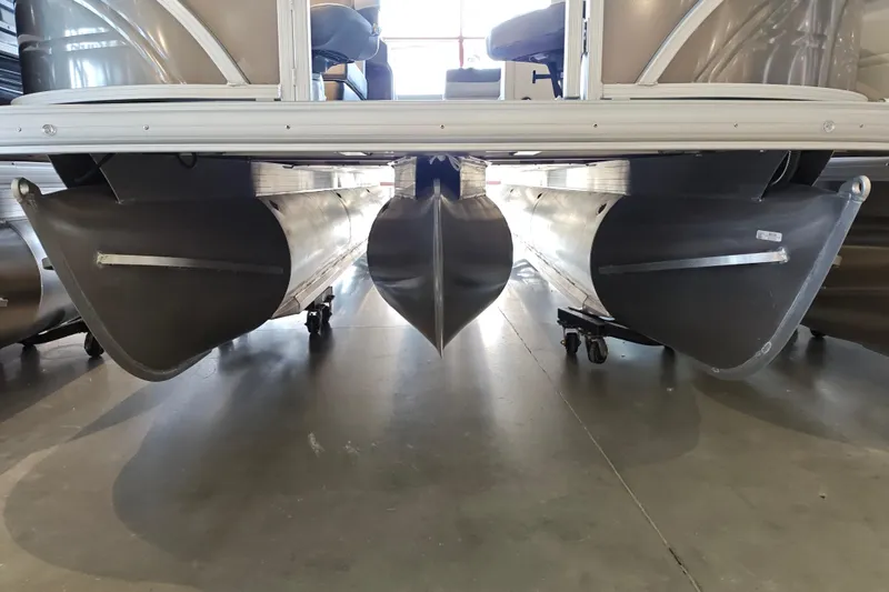 Slide: The Image of 2026 Sun Tracker Fishin' Barge 22 XP3 pontoon boat hulls on display in showroom. - 100