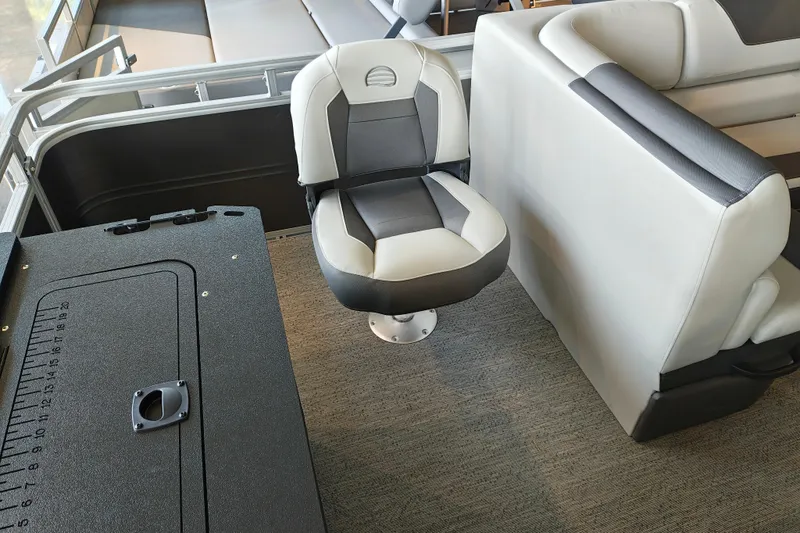Slide: The Image of 2026 Sun Tracker Fishin' Barge 22 XP3 interior with swivel seat and storage compartment. - 110