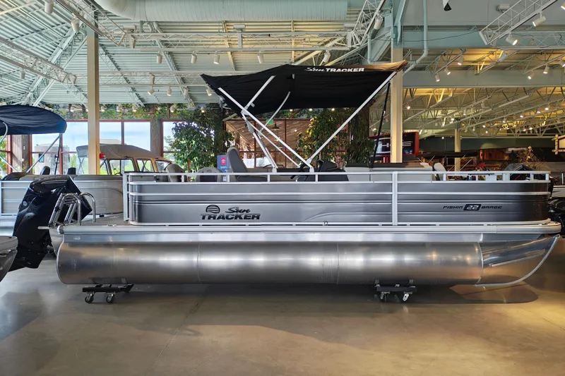 The Image of 2026 Sun Tracker Fishin' Barge 22 XP3 pontoon boat displayed in a showroom. - 98
