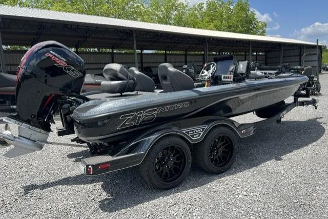 Slide: The Image of 2026 Nitro Z18 boat with dual axle trailer, parked outdoors under a clear sky. - 101