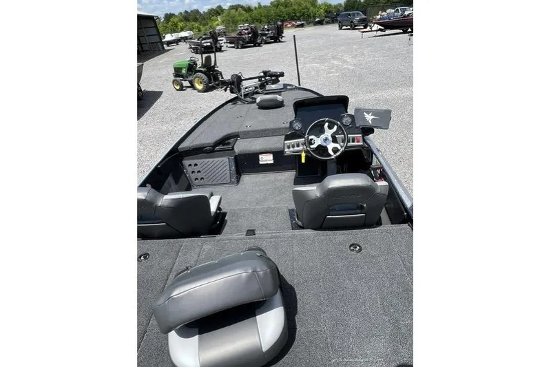 Slide: The Image of 2026 Nitro Z18 boat interior with steering wheel and seating, parked outdoors. - 92