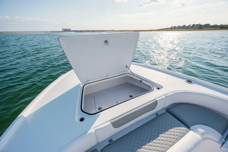 Slide: The Image of Caymas 26 HB 2026 boat with open storage compartment on the water. - 13