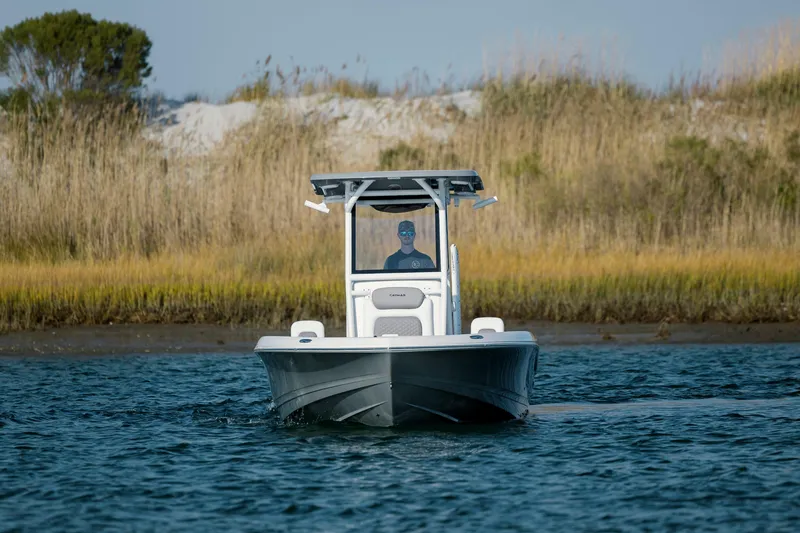 Slide: The Image of Caymas 26 HB 2026 boat on calm water near coastal landscape. - 7