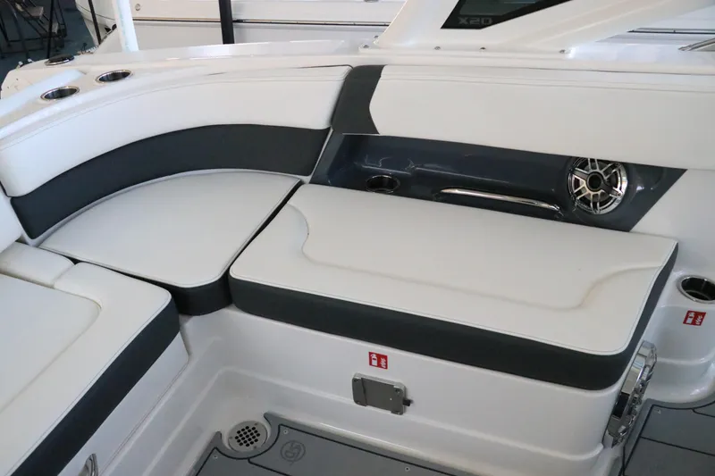 Slide: The Image of 2026 Chaparral 280 OSX boat storage compartment with open seat and branded upholstery. - 18