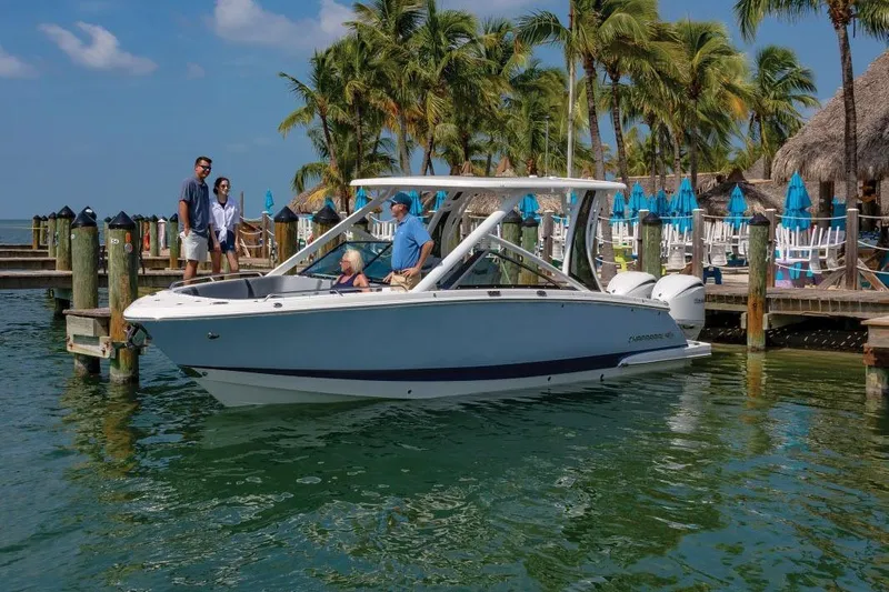 Slide: The Image of 2026 Chaparral 280 OSX boat in showroom, sleek design, white exterior. - 2