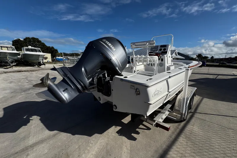 Slide: The Image of 2018 Chaos 21 Tarpon Bay boat with outboard motor in a marina setting. - 2