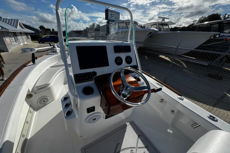 Slide: The Image of 2018 Chaos 21 Tarpon Bay boat dashboard with steering wheel and control panel. - 21