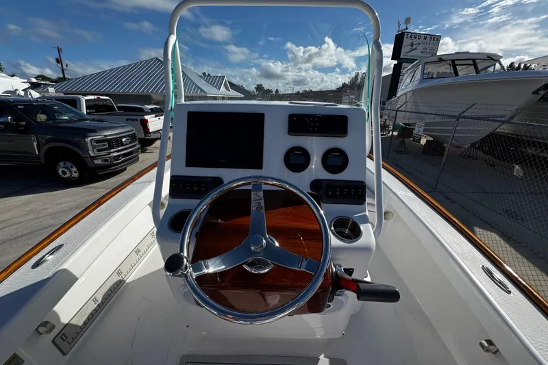 Slide: The Image of 2018 Chaos 21 Tarpon Bay boat dashboard with steering wheel and controls. - 22