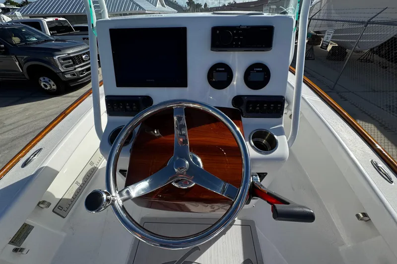 Slide: The Image of 2018 Chaos 21 Tarpon Bay boat interior with white seating and steering wheel. - 24