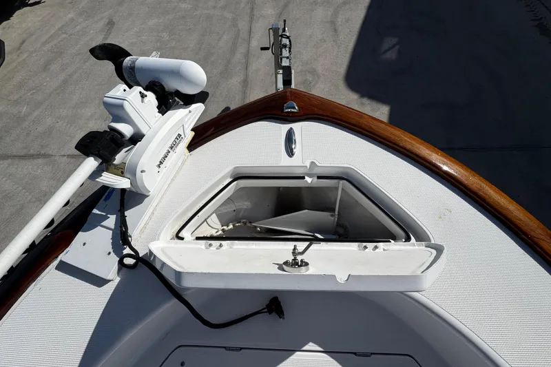 Slide: The Image of 2018 Chaos 21 Tarpon Bay boat deck with trolling motor, parked near vehicles. - 8