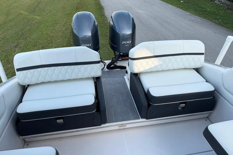 Slide: The Image of 2021 Regal 29 OBX boat interior with dual outboard engines and cushioned seating. - 12