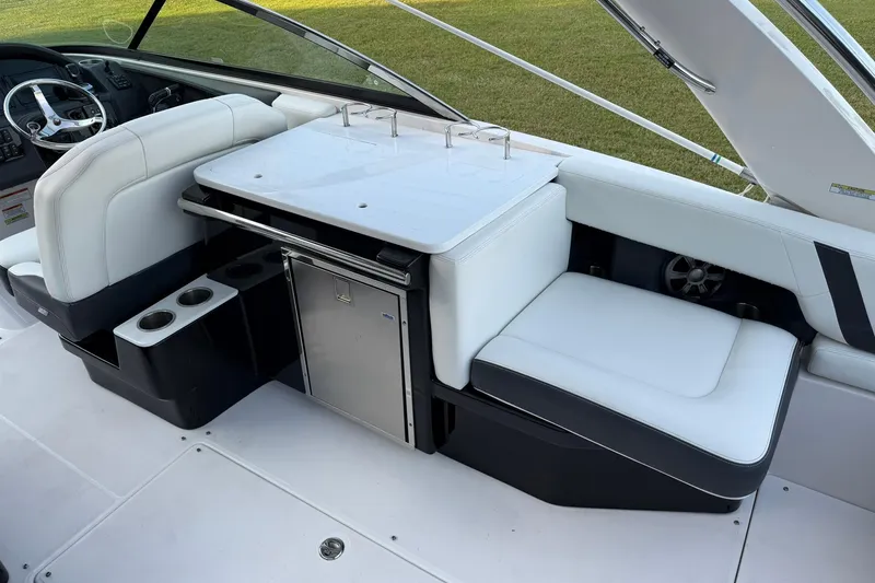 Slide: The Image of 2021 Regal 29 OBX boat interior with white seating and compact kitchenette. - 16