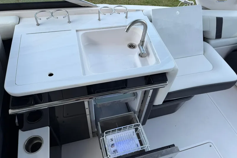 Slide: The Image of 2021 Regal 29 OBX boat kitchenette with sink, faucet, and storage compartments. - 17