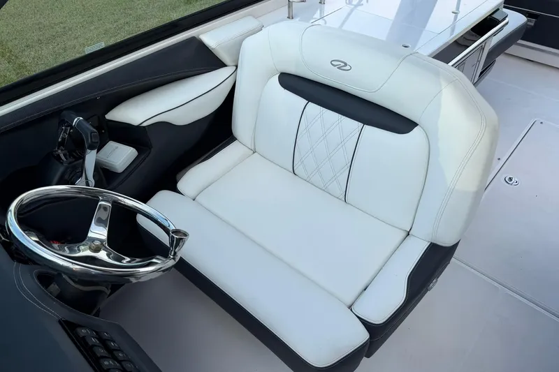 Slide: The Image of 2021 Regal 29 OBX boat interior with white leather seating and steering wheel. - 20