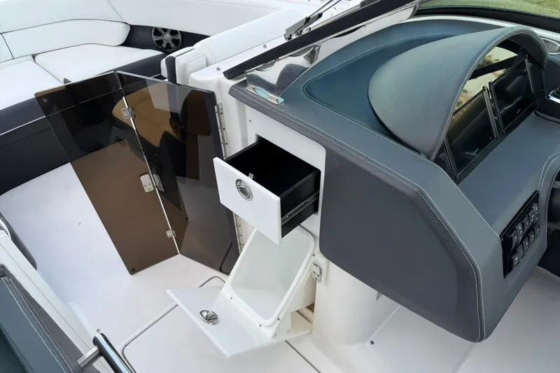 Slide: The Image of 2021 Regal 29 OBX boat interior with open storage compartments and sleek dashboard design. - 22