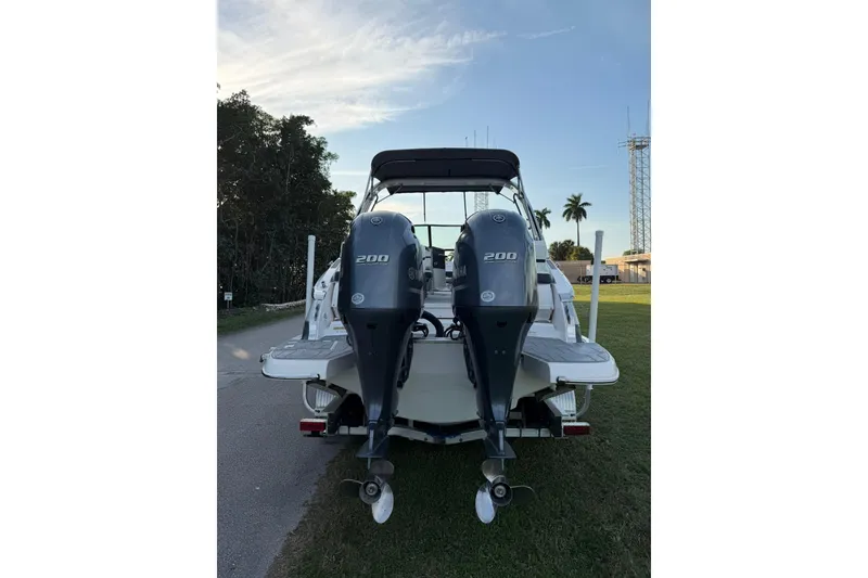 Slide: The Image of 2021 Regal 29 OBX boat with dual Yamaha 200 outboard engines, parked on grass. - 3