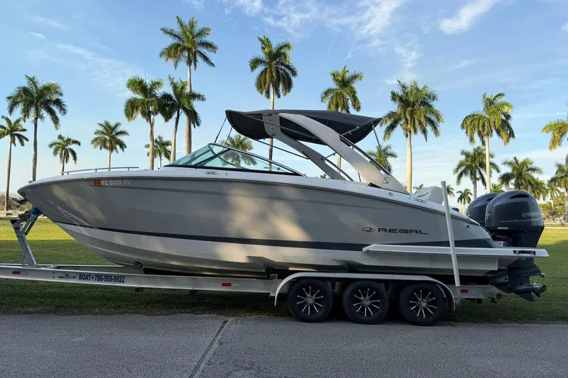 Slide: The Image of 2021 Regal 29 OBX boat on trailer with palm trees in background. - 5
