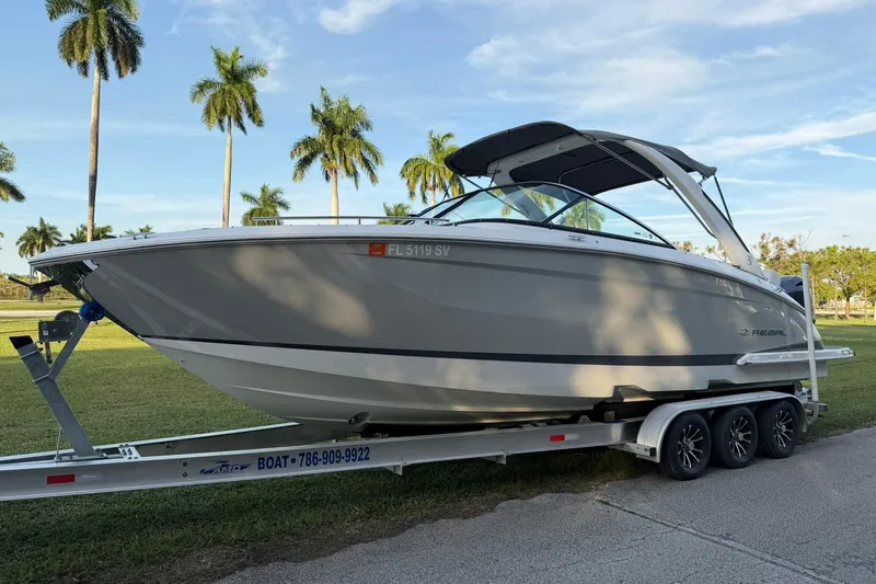 Slide: The Image of 2021 Regal 29 OBX boat on trailer with palm trees in the background. - 6