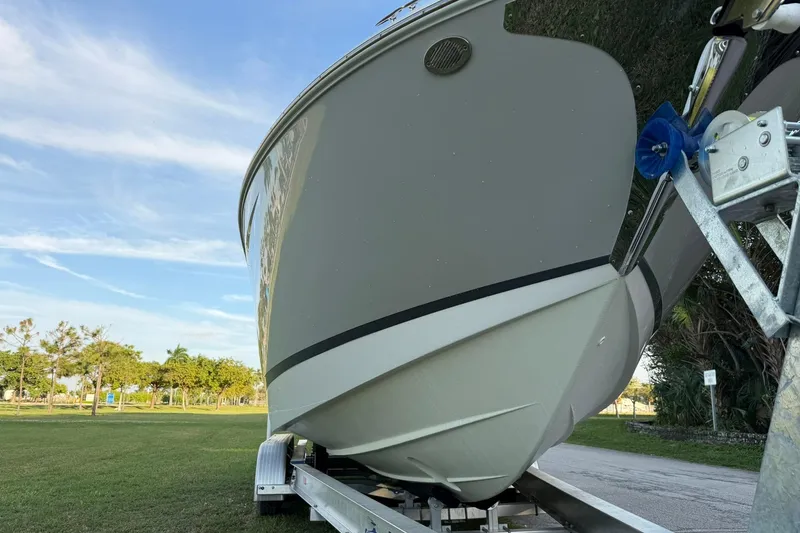 Slide: The Image of 2021 Regal 29 OBX boat on trailer, parked on grassy area under blue sky. - 8