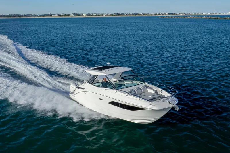 Slide: The Image of 2020 Sea Ray Sundancer 320 Outboard cruising on open water, showcasing sleek design and performance. - 11