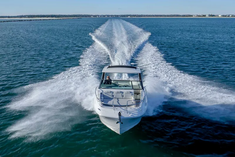 Slide: The Image of 2020 Sea Ray Sundancer 320 Outboard cruising on open water, leaving a wake trail. - 13