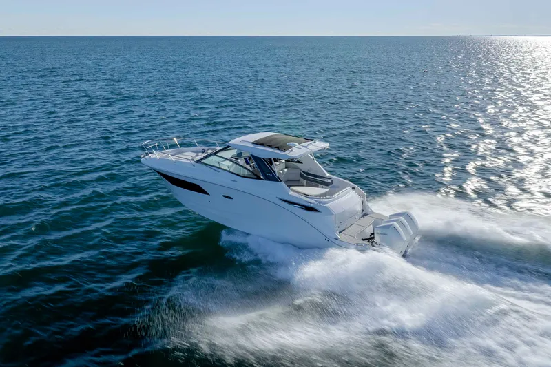 Slide: The Image of 2020 Sea Ray Sundancer 320 Outboard cruising on open water, creating a dynamic wake. - 15