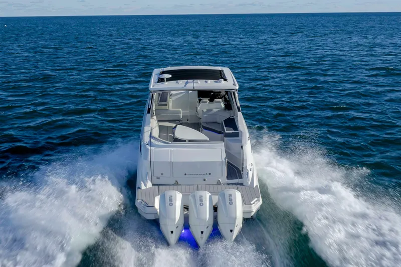 Slide: The Image of 2020 Sea Ray Sundancer 320 Outboard cruising on open water, rear view. - 16