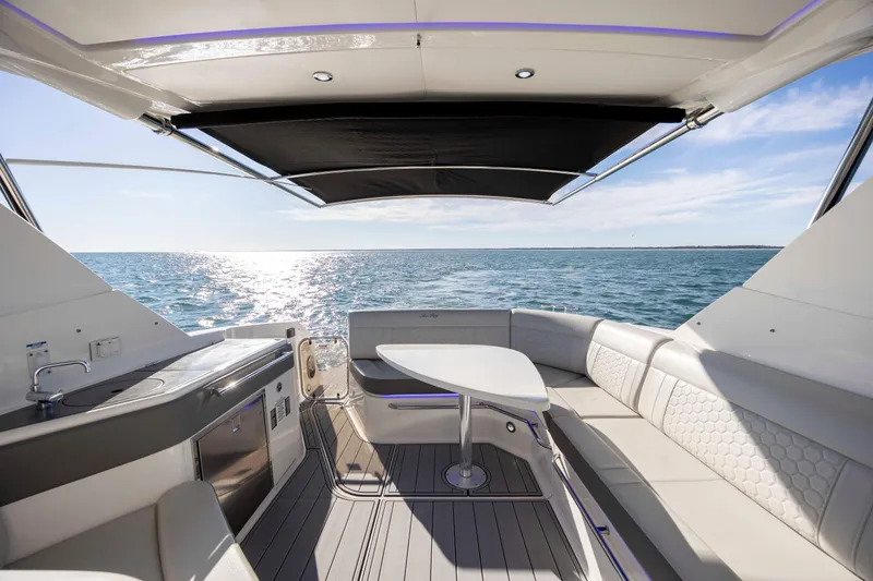 Slide: The Image of 2020 Sea Ray Sundancer 320 Outboard interior with ocean view, featuring seating and table. - 19