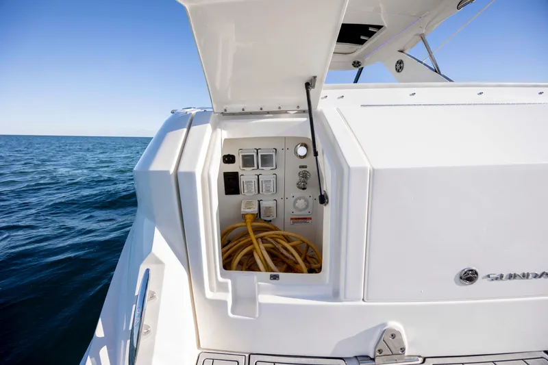 Slide: The Image of 2020 Sea Ray Sundancer 320 Outboard with open electrical panel, ocean backdrop. - 31