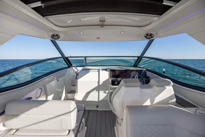 Slide: The Image of 2020 Sea Ray Sundancer 320 Outboard cockpit with ocean view, featuring modern helm and seating. - 33