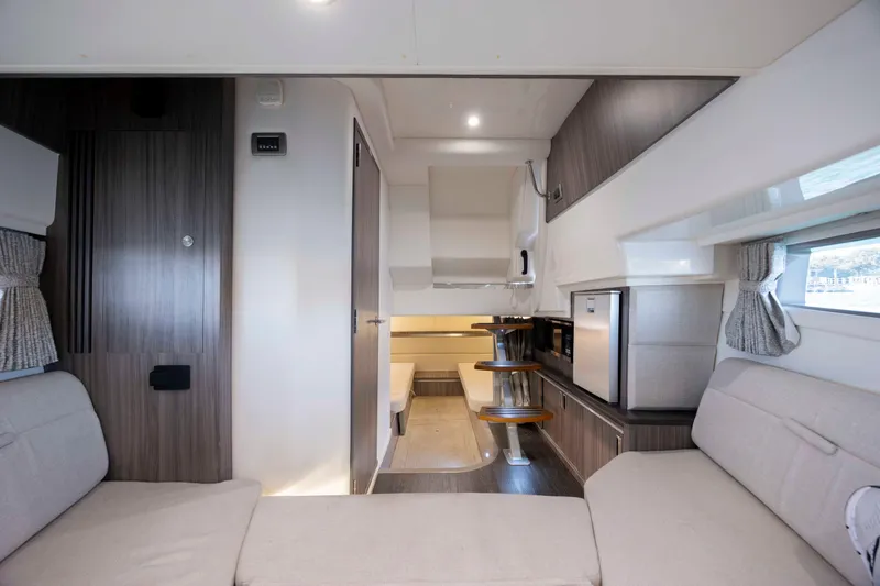Slide: The Image of Interior of 2020 Sea Ray Sundancer 320 Outboard, featuring modern seating and kitchenette. - 37