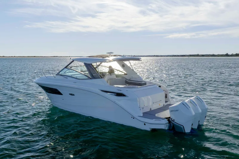 Slide: The Image of 2020 Sea Ray Sundancer 320 Outboard cruising on open water under a clear sky. - 4