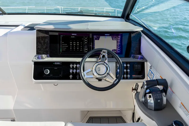 Slide: The Image of 2020 Sea Ray Sundancer 320 Outboard helm with modern controls and navigation display. - 45