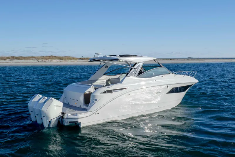 Slide: The Image of 2020 Sea Ray Sundancer 320 Outboard cruising on open water under clear skies. - 6