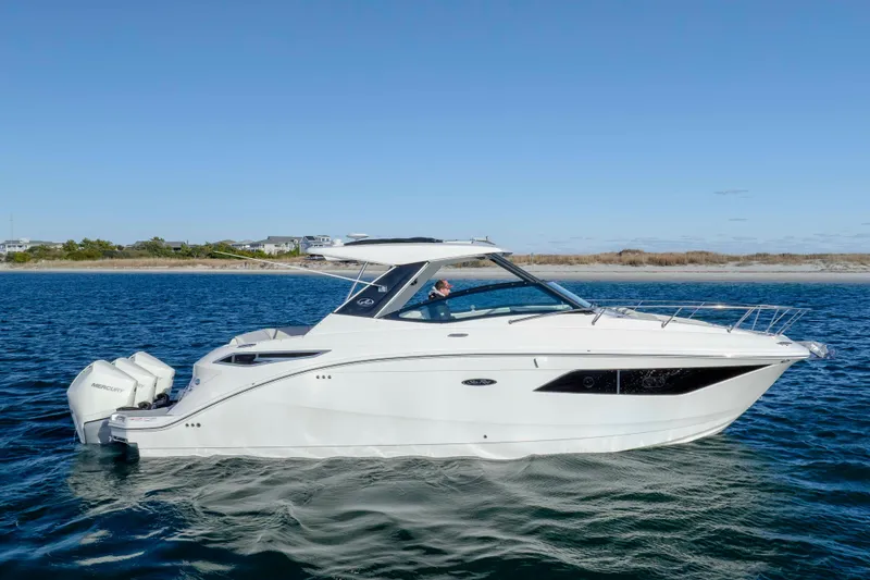 Slide: The Image of 2020 Sea Ray Sundancer 320 Outboard cruising on open water under clear skies. - 7