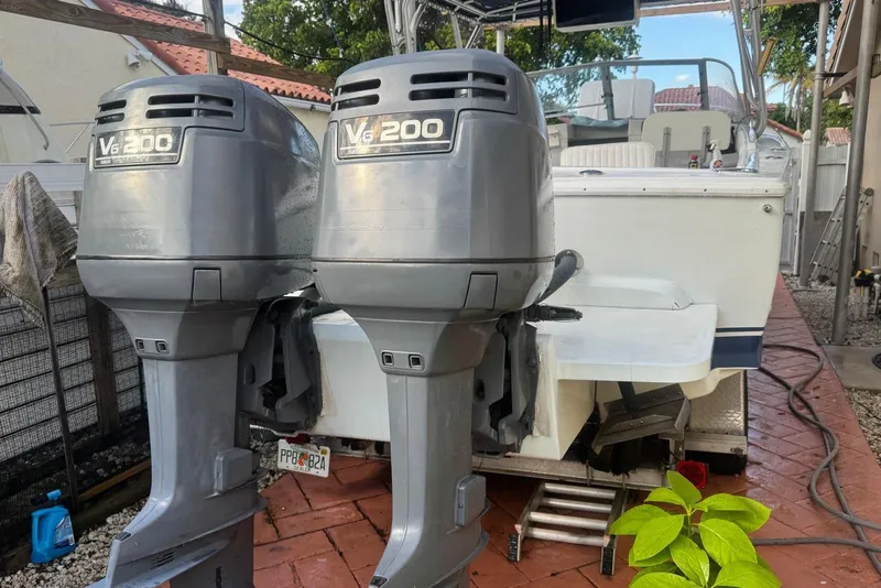 Slide: The Image of 1962 Bertram 25 Moppie with twin V6 200 outboard engines, parked on brick driveway. - 4