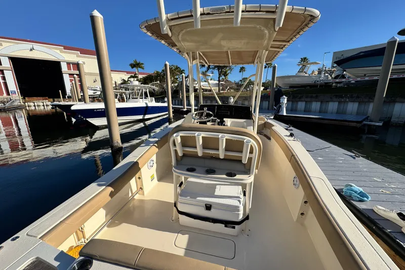 Slide: The Image of 2022 Scout 215 XSF boat docked at marina, featuring spacious deck and seating. - 11