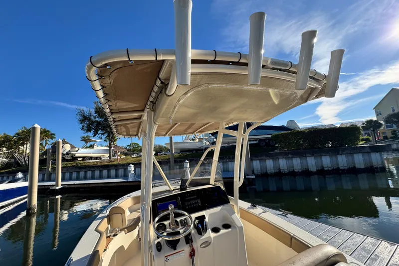 Slide: The Image of 2022 Scout 215 XSF boat docked, featuring a T-top and steering console. - 15
